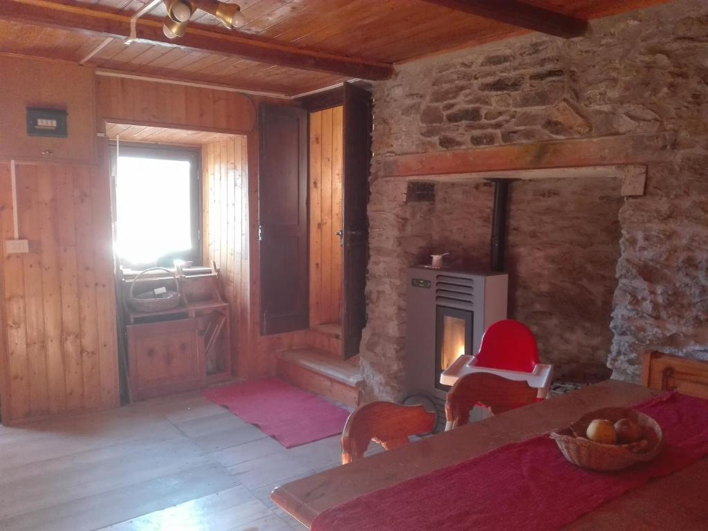 a living room with a stone fireplace in a house at Baita nonno Guido in Moncenisio