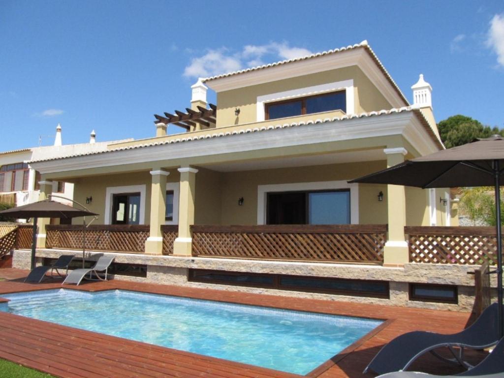 een huis met een zwembad ervoor bij Villa Tiago in Loulé