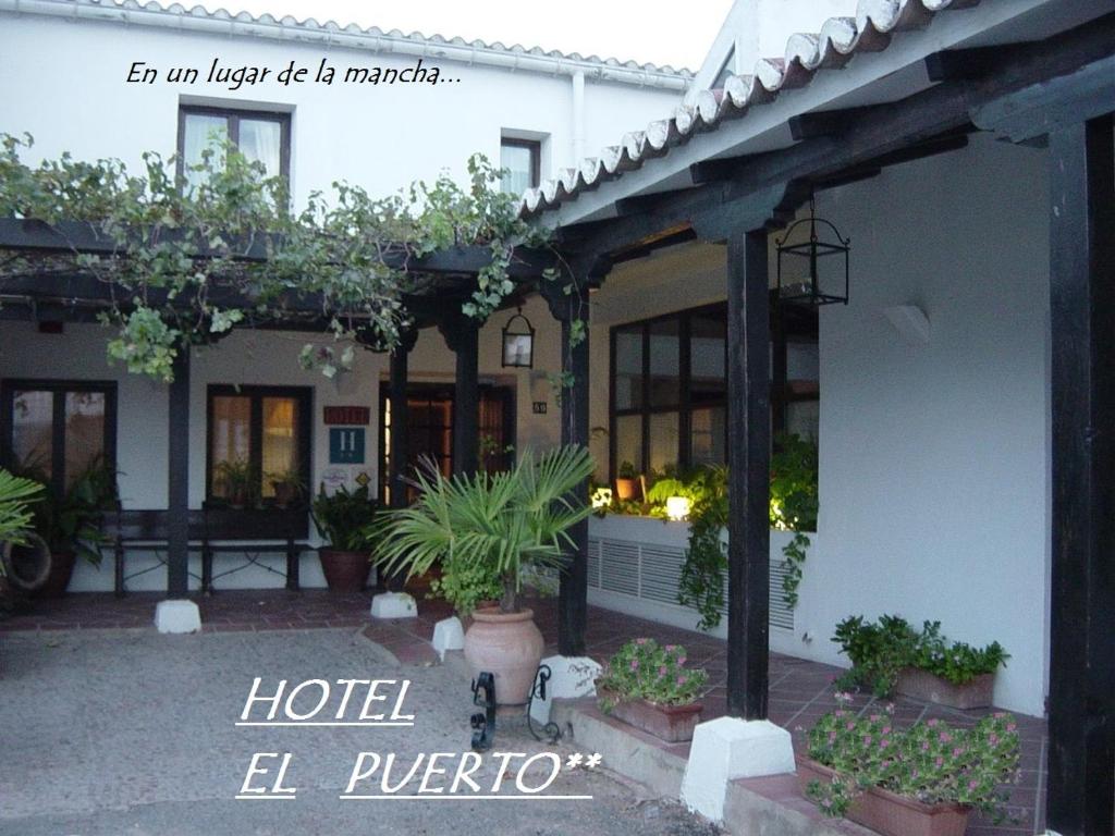 an exterior view of a hotel with potted plants at Hotel El Puerto in Puerto Lápice