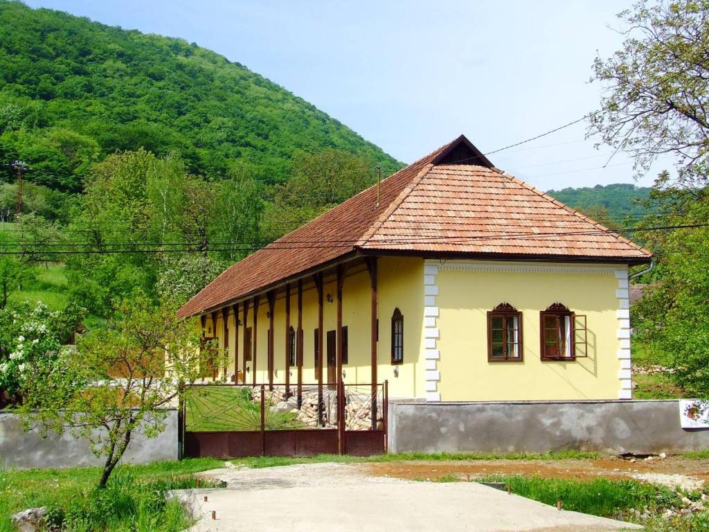 un pequeño edificio amarillo con techo marrón en Magdolna Ház, en Szögliget