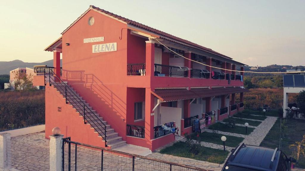 een oranje gebouw met een auto ervoor geparkeerd bij Ferienhaus Elena in Agios Georgios