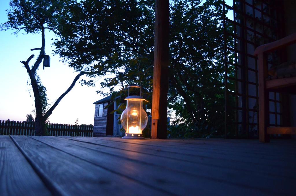 a lit up vase sitting on top of a wooden deck at Dom Wakacyjny - Siedlisko Gutowo in Lidzbark