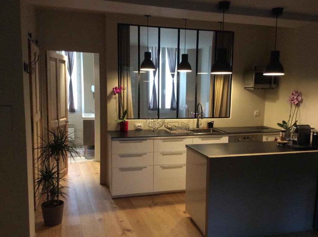 a kitchen with white cabinets and a large mirror at T2 centre ville avec extérieur in Avignon