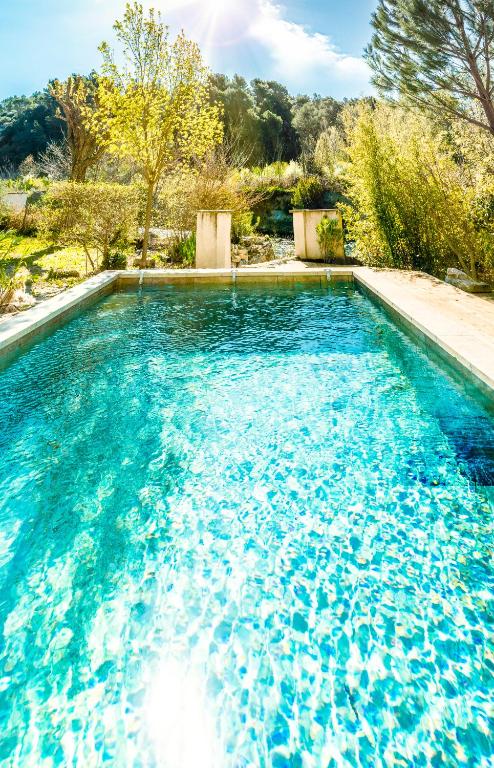 a swimming pool with blue water in a yard at A jewel by the river! in Fontaine-de-Vaucluse