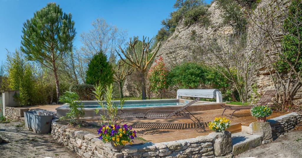 a swimming pool in a garden with flowers in a yard at A jewel by the river! in Fontaine-de-Vaucluse
