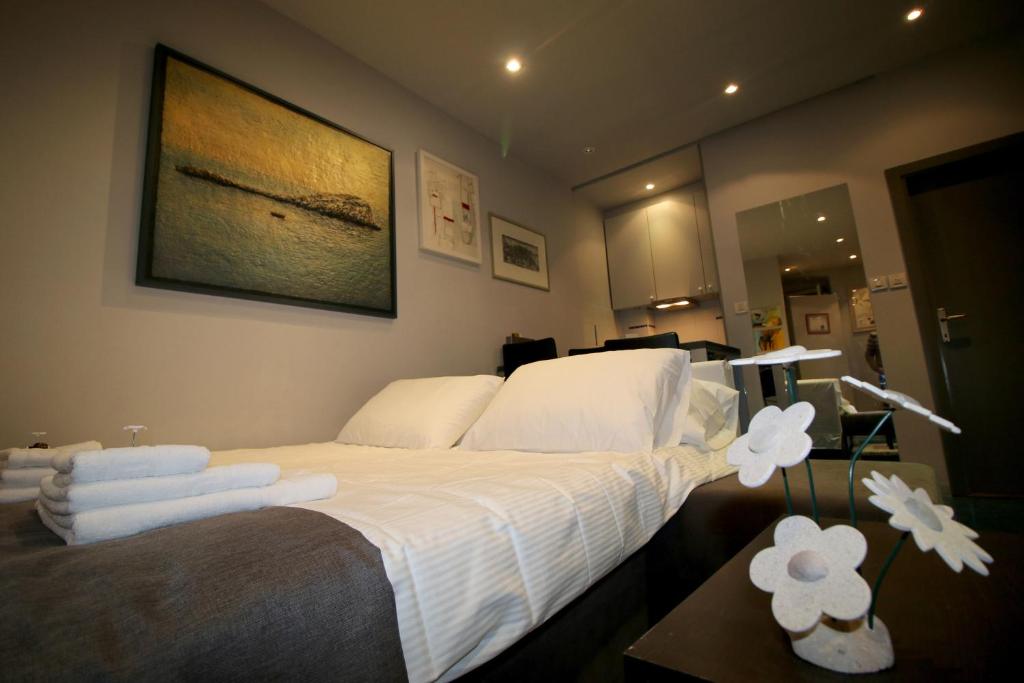 Schlafzimmer mit einem Bett mit weißer Bettwäsche und Handtüchern in der Unterkunft Studio apartment ART in Split