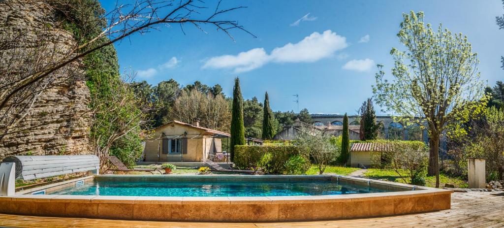 a swimming pool in a yard with a house at A jewel by the river! in Fontaine-de-Vaucluse