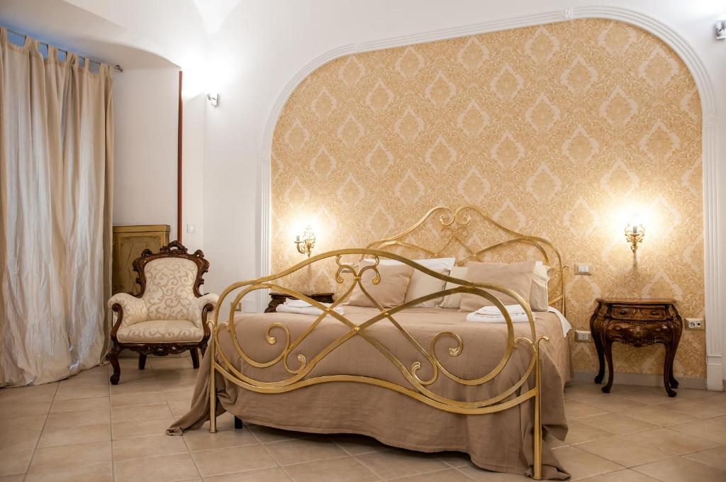 ナポリにあるdomus sanfeliceのベッドルーム1室(大型ベッド1台、椅子2脚付)