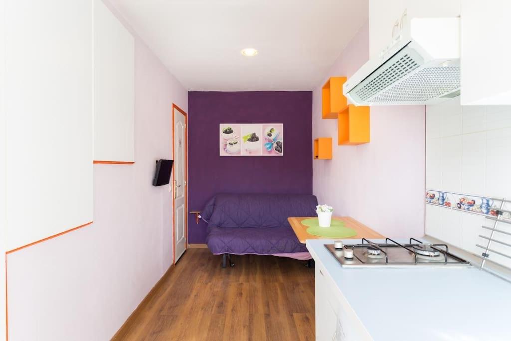 サン・イシドロにあるEstudio moderno y acogedor, a 5 minutos de la playaのキッチン(紫色のソファ、テーブル付)