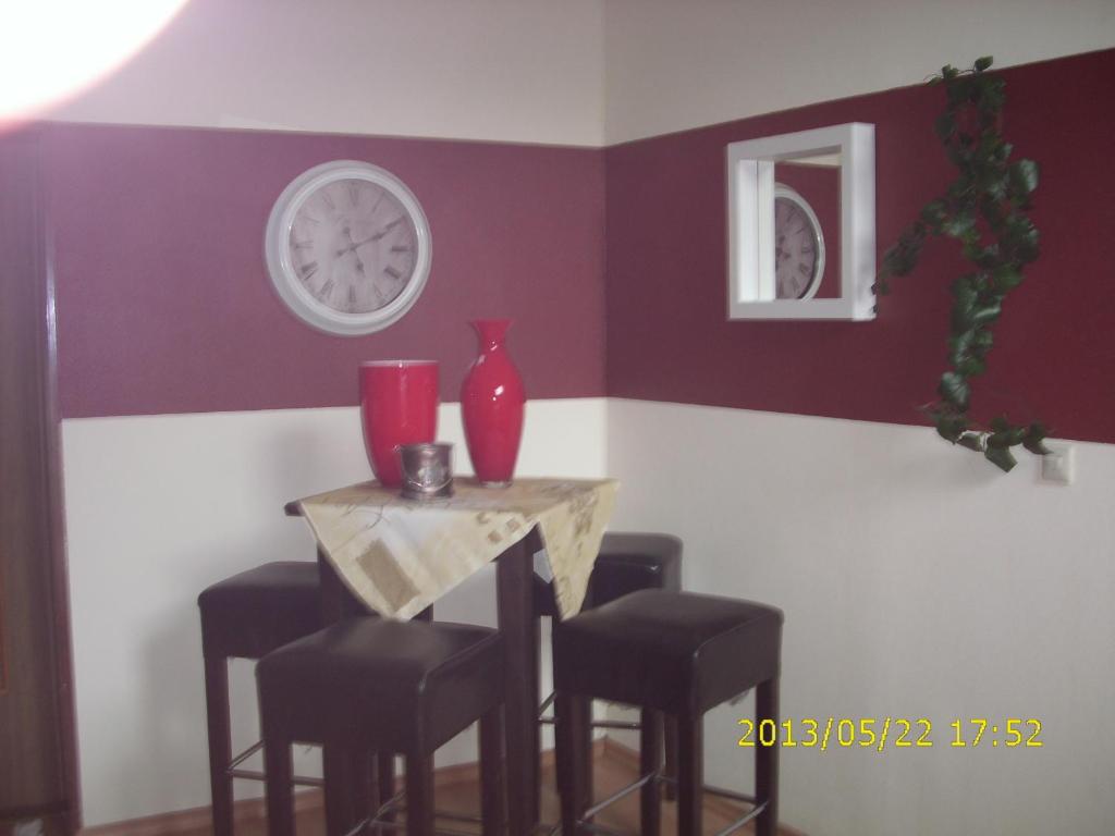 a dining room with a table with stools and a red wall at Endbach-life in Bad Endbach