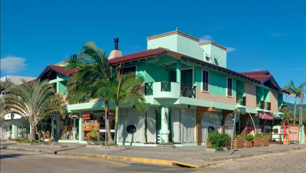 un edificio verde y blanco en la esquina de una calle en Solar de Garopaba, en Garopaba