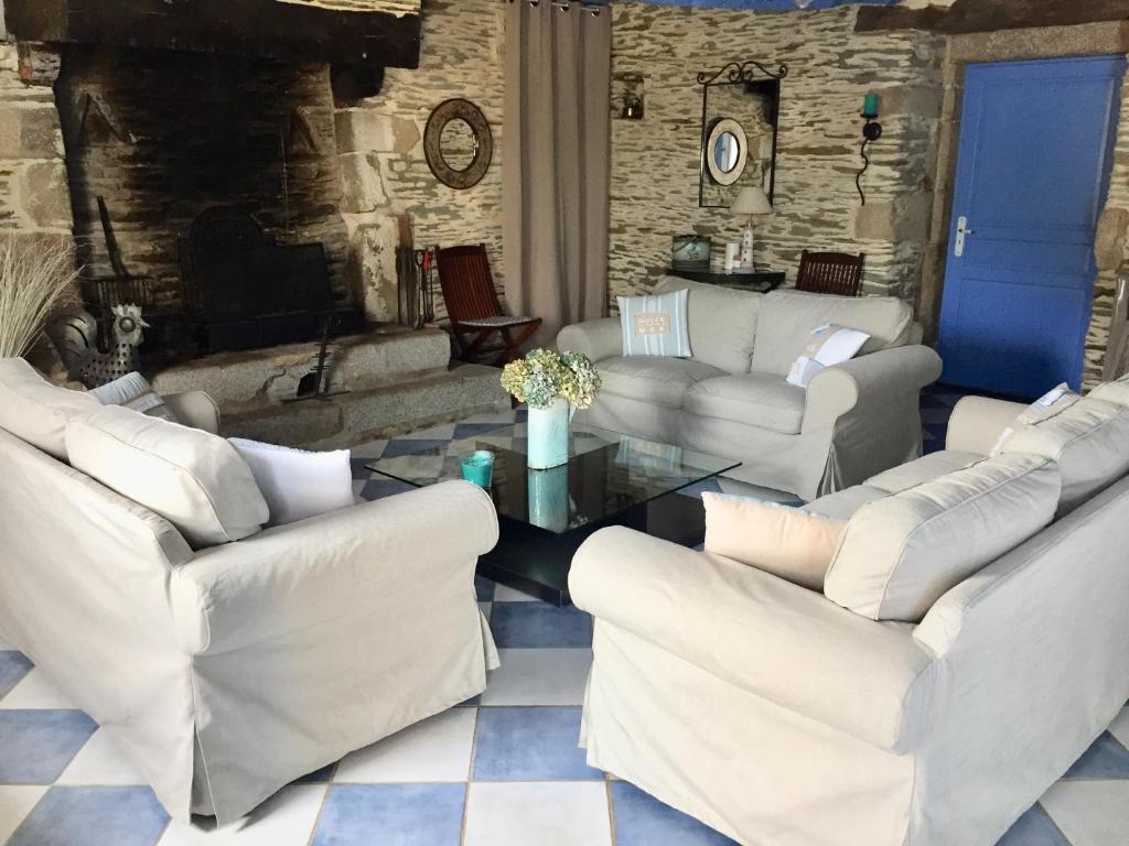 a living room with white couches and a table at Le gîte d'Arthur in Guillac