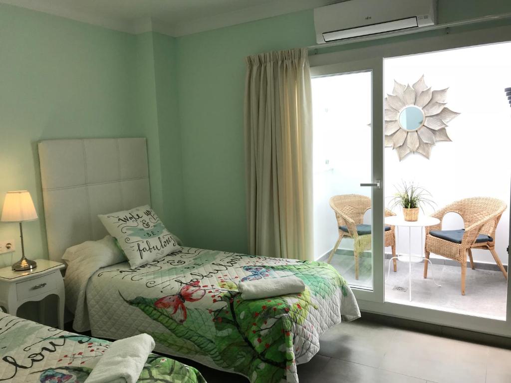 sypialnia z 2 łóżkami i przesuwnymi szklanymi drzwiami w obiekcie Pensión La Herradura w mieście La Herradura