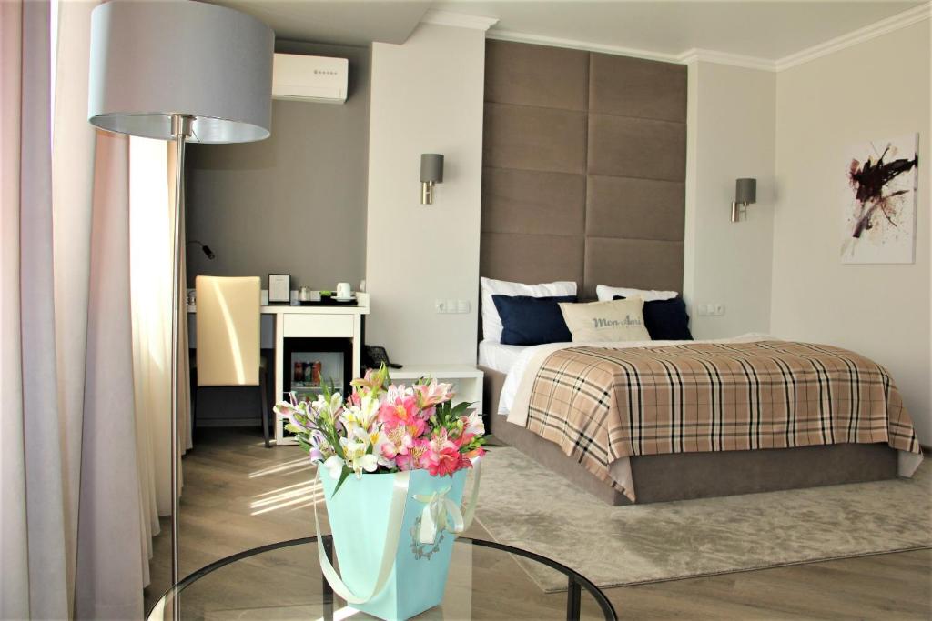 Mon Ami Villa في كيشيناو: غرفة نوم بسرير وطاولة مع ورد