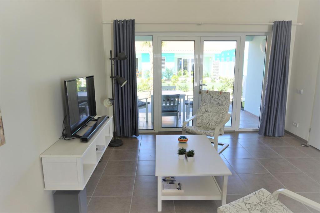 a living room with a tv and a table at Blije Rust 10 in Willemstad
