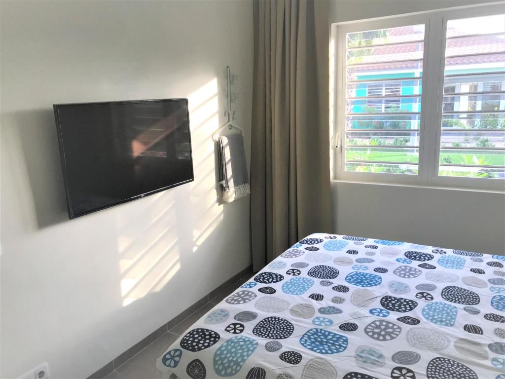 a bedroom with a bed and a flat screen tv at Blije Rust 10 in Willemstad