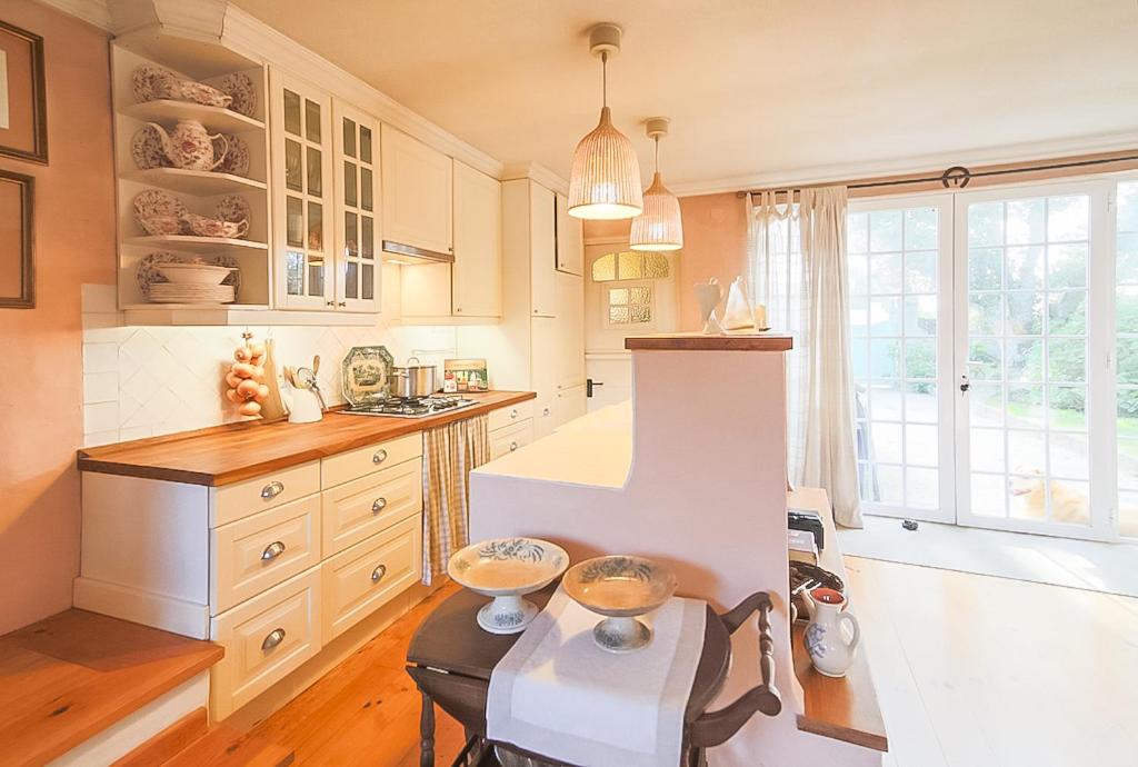 a kitchen with white cabinets and a table at A House in The Woods in Sintra