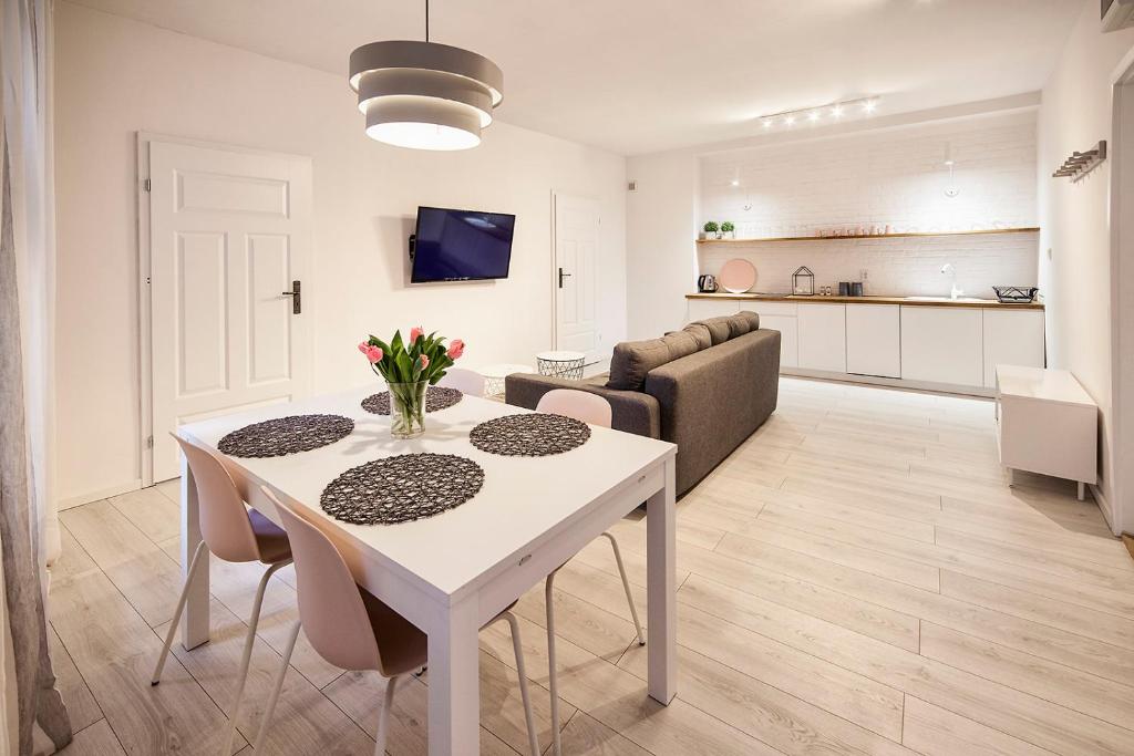 a living room with a white table and a couch at Apartamenty toruńskie pod Krzywą Wieżą in Toruń