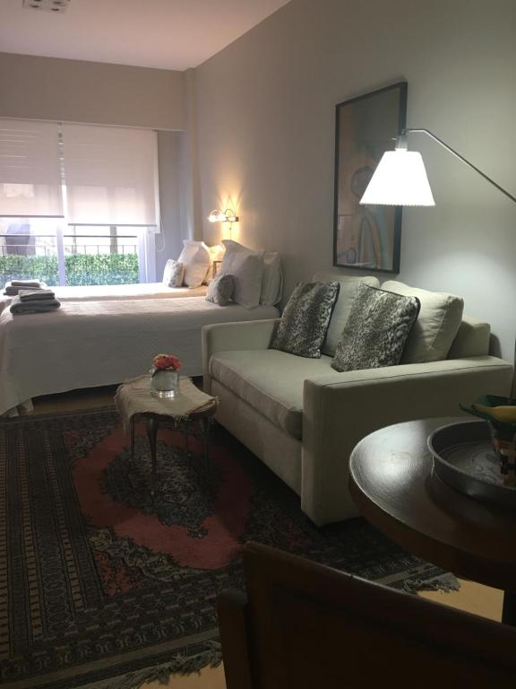 Habitación de hotel con 2 camas y sofá en Studio Juncal en Buenos Aires