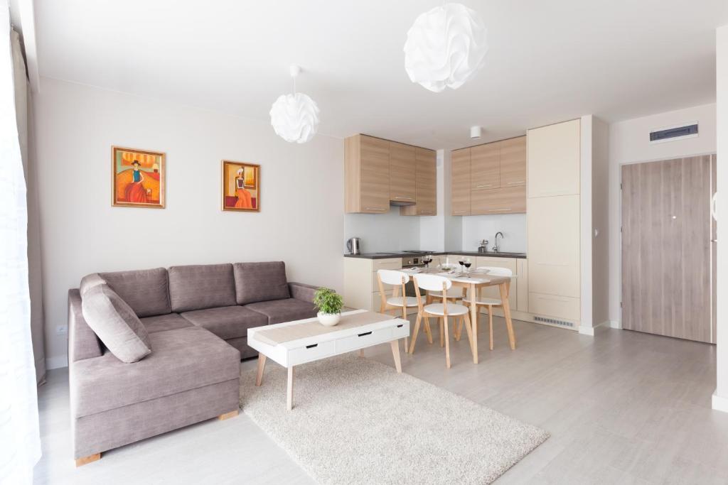 レバルにあるRaval Apartments - Soft Beigeのリビングルーム(ソファ、テーブル付)、キッチンが備わります。