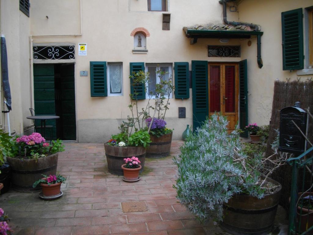 a house with green shutters and potted plants in front of it at La Corte del Frate in Podere Panzano