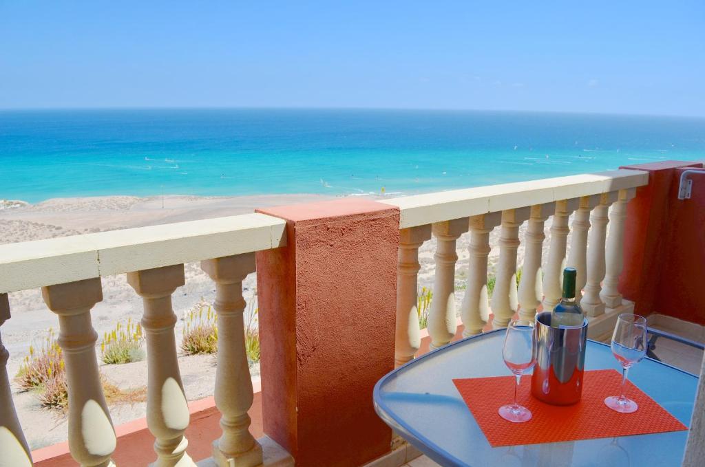 a glass table on a balcony with a view of the ocean at Residencial Playa Paraiso in Costa Calma