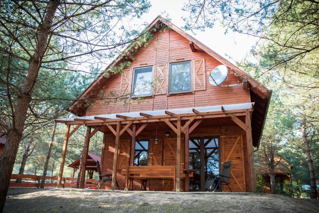 eine Hütte im Wald mit einem großen Fenster in der Unterkunft Domki w Borach in Wycinki