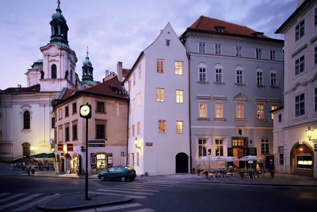 a group of buildings with a clock on a street at U Tří Bubnů in Prague