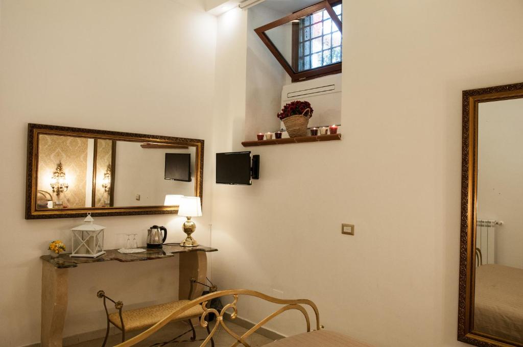 ナポリにあるDomus Sanfelice Suiteのリビングルーム(鏡、椅子付)