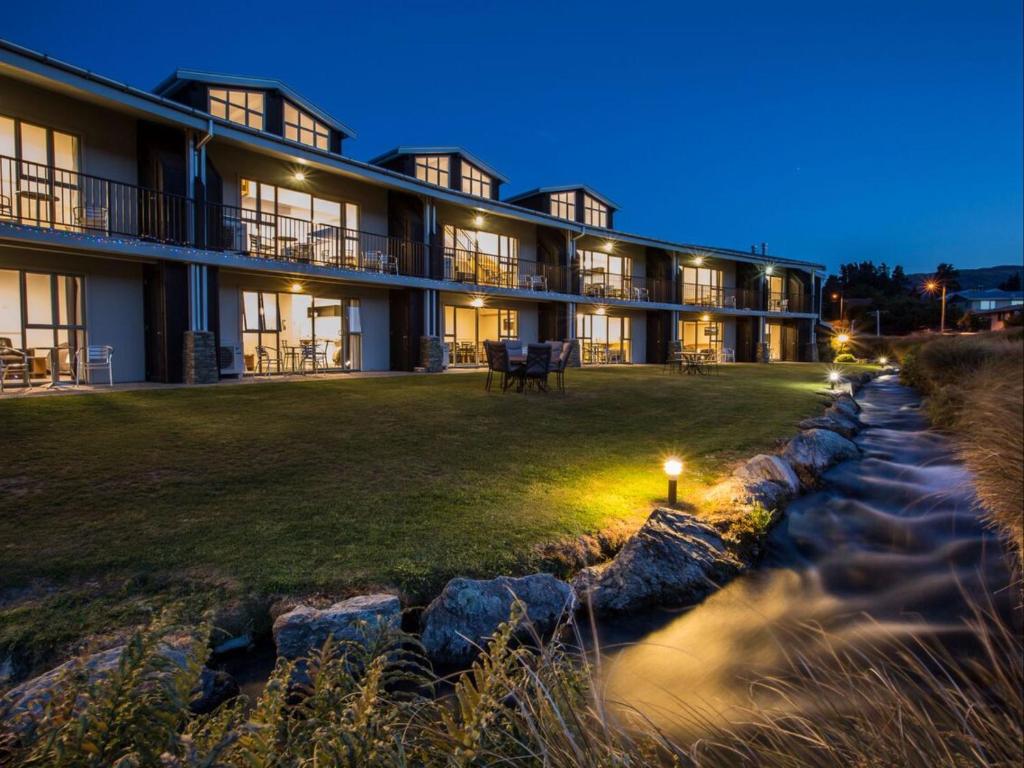 un edificio con un río delante de él en Clearbrook Motel & Serviced Apartments, en Wanaka