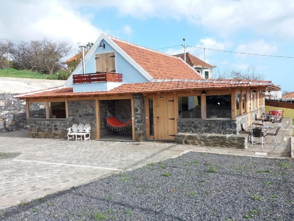 a house with a red roof and a patio at Vila Vinha in Arco da Calheta