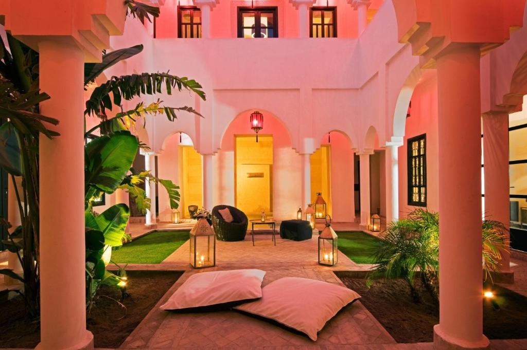 a courtyard of a building with lights and plants at Riad Capaldi in Marrakesh