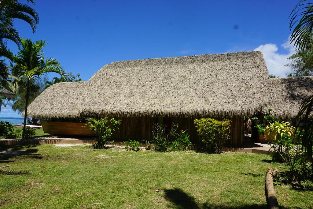 a hut with a straw roof on the beach at Hôtel Atiapiti in Opoa