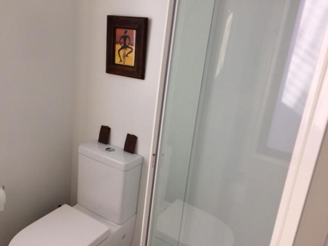 a white bathroom with a toilet and a shower at Entabeni in Raglan