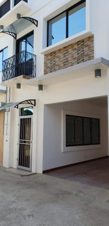 a white building with a gate and a garage at Kdc Homes in Puerto Princesa City