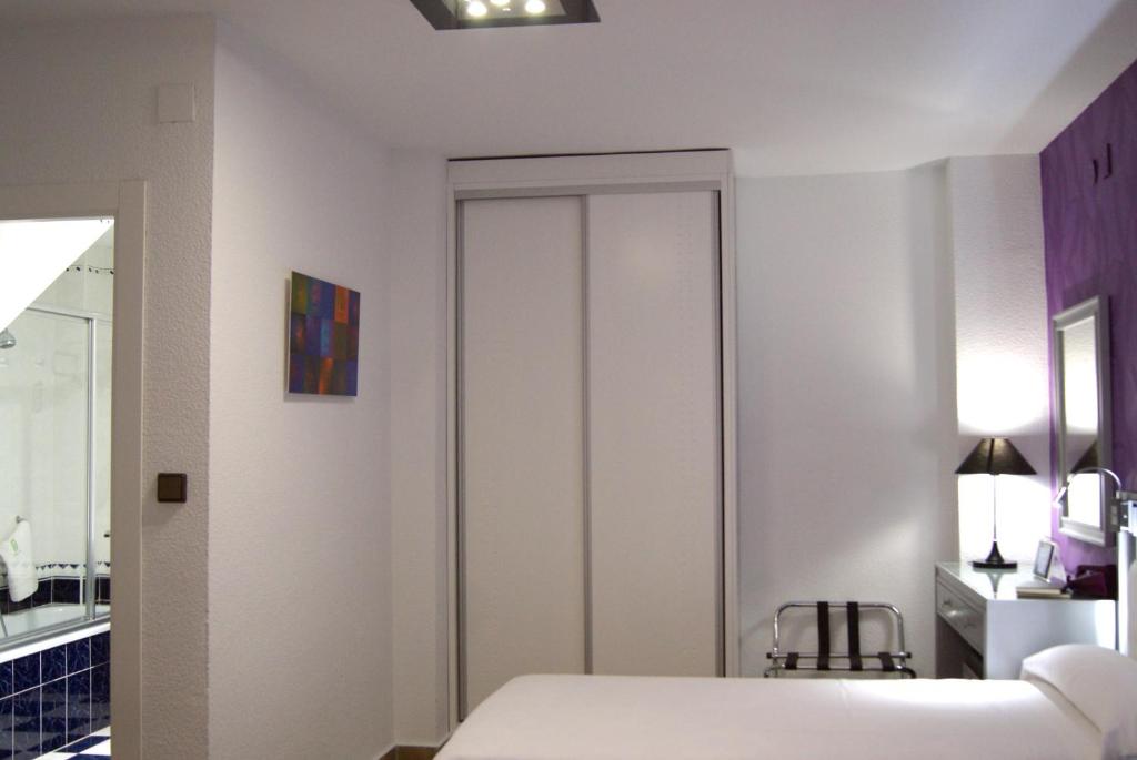 a bedroom with a bed and a closet at Hotel Molinos in Granada