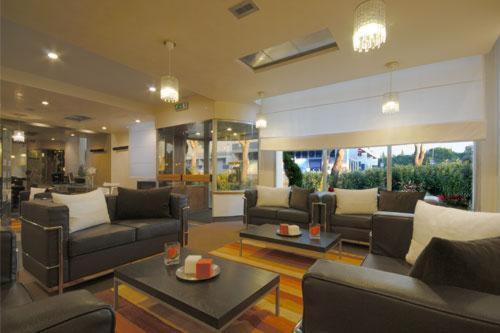 una gran sala de estar con sofás y mesas. en Hotel First, en Calenzano