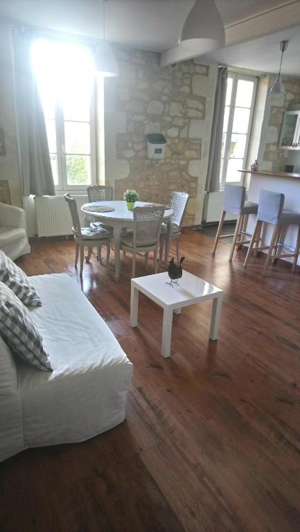 a living room with a couch and a table and chairs at Entre Estuaire et Citadelle in Blaye