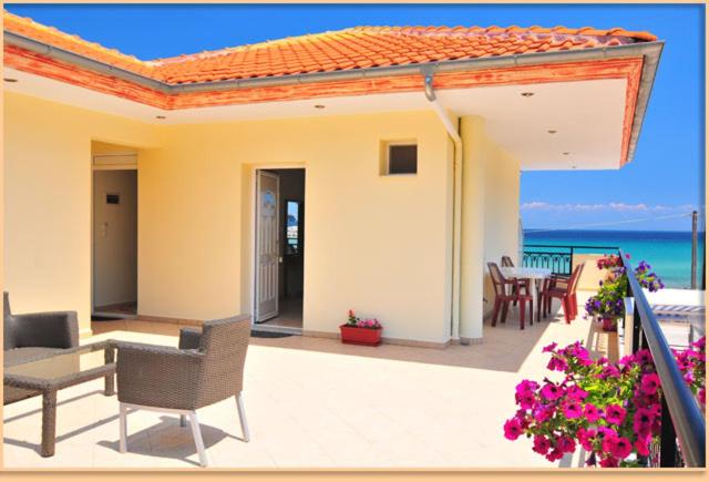 a patio with a table and chairs and the ocean at Studios-Heaven in Chrysi Ammoudia