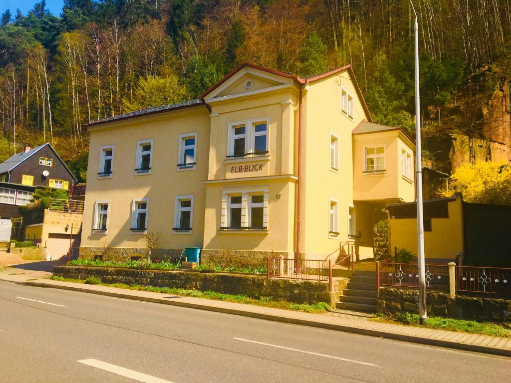 een geel huis aan de straatkant bij Apartmentshaus Elbblick Zimmer "Bergblick" in Bad Schandau