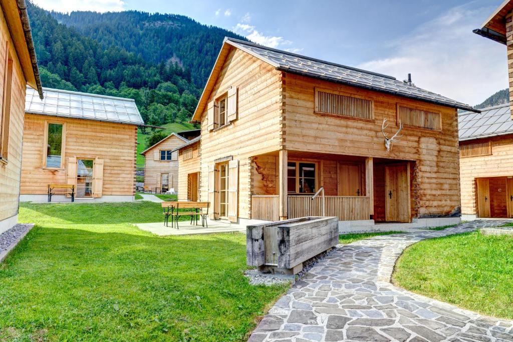 a wooden house with a bench in the yard at CASALPIN Chalets in Brand