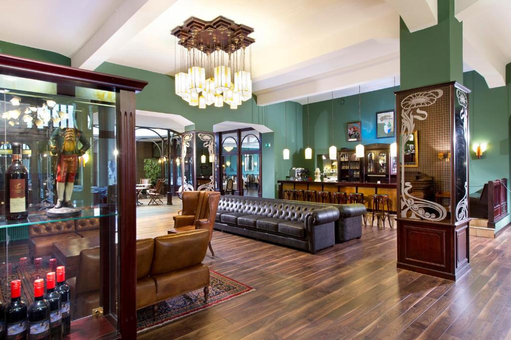 a bar with a couch and a chandelier at Tryp by Wyndham Kassel City Centre in Kassel