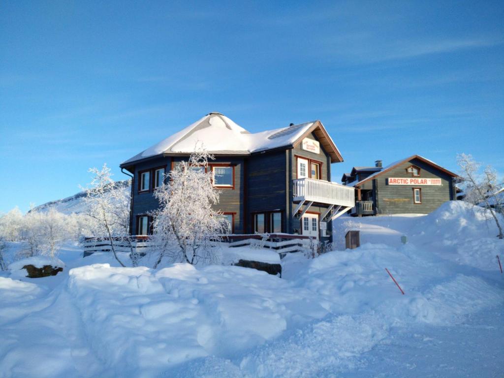 a house covered in snow in front at Arctic Polar Holiday Village in Kilpisjärvi
