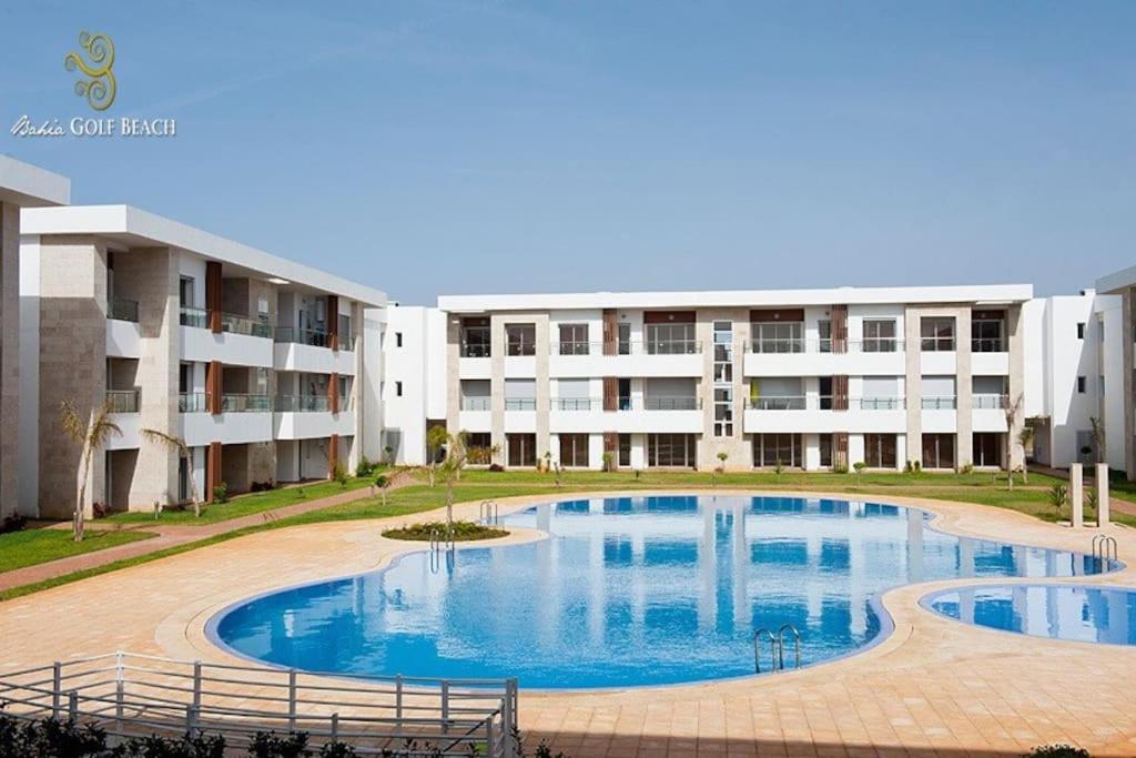 a large swimming pool in front of a building at Appartement Odyssee - Bahia Golf Beach in Kasba Bou Hamira