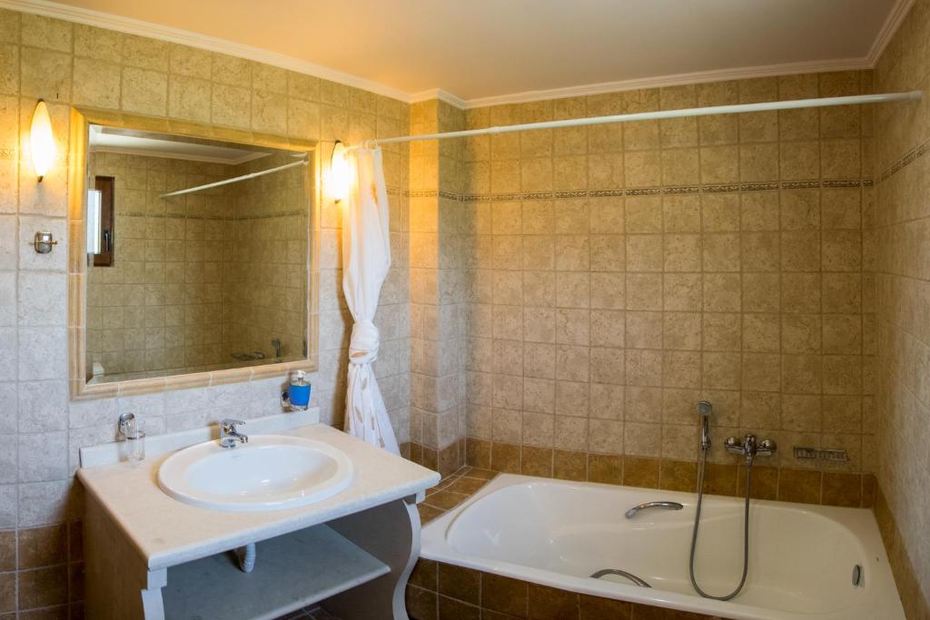 W łazience znajduje się umywalka i wanna. w obiekcie Villa Tinadora w mieście Agia Triada