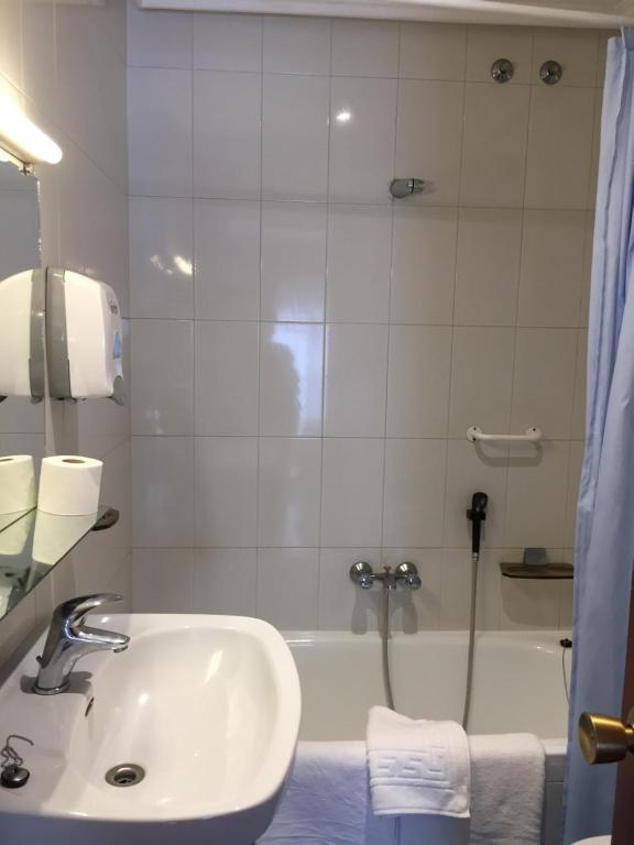 a bathroom with a sink and a shower and a tub at Hotel Derby in Carballino