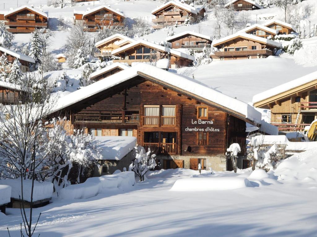 uma cabana de madeira está coberta de neve em Chambres d'Hôtes Le Barna em La Clusaz