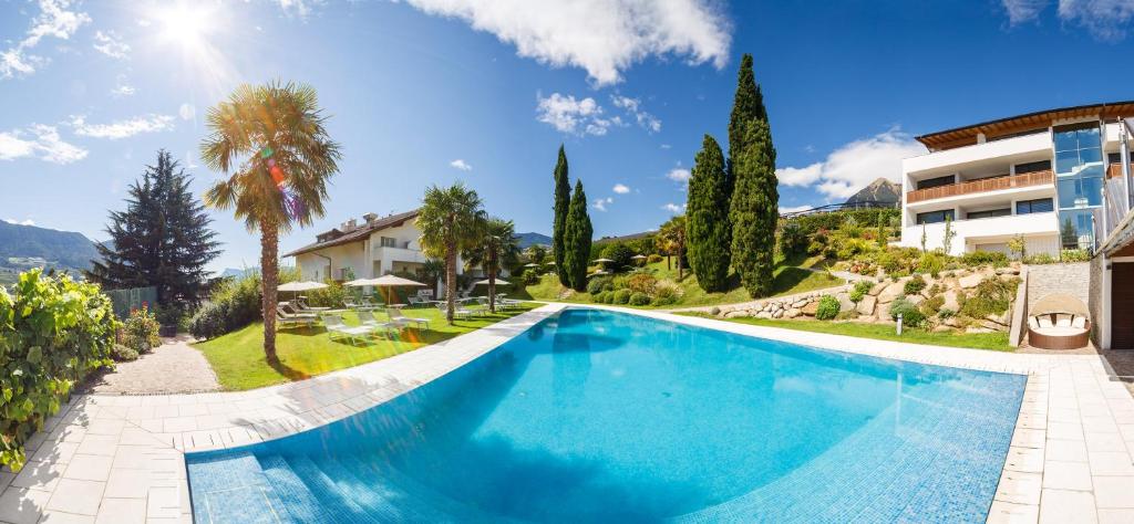 - une piscine en face d'une maison dans l'établissement Hotel Appartement Krone, à Tirolo