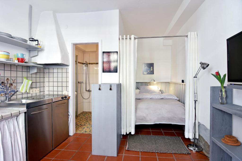 eine Küche mit einem Kühlschrank und ein Bett in einem Zimmer in der Unterkunft Apartmenthaus Duderstadt in Duderstadt