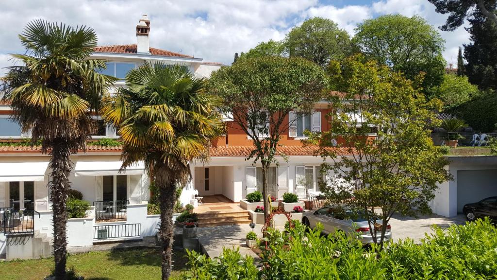 a house with palm trees in front of it at Corte dei merli Apartments in Rovinj